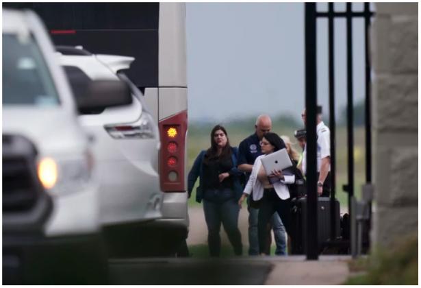 Democrats from the Texas Legislature arrive by bus to board a private plane in Austin to travel to Washington, D.C., on Monday. The lawmakers fled the state to try to block action on GOP election bills. Eric Gay/AP