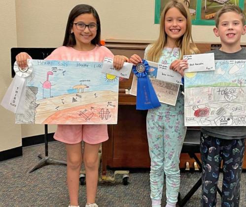 At right, from left, third grade poster winners were Jaylee Garcia, third place; Parker Kellison, first place; and Rhett Rainwater, second place.