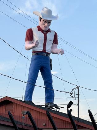 GO AHEAD, MAKE MY DAY “Dude Man” atop a Gallup used-car dealership was once a Paul Bunyan figure—but now he’s packing heat instead. | THE TEXAS SPUR