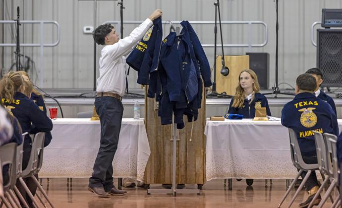CEREMONIAL HANGING OF FFA JACKETS marked the end of the 2024 term for District FFA officers, including Rylee Austin, president.