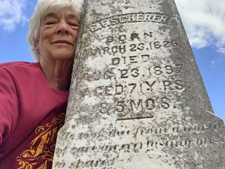 Snuggling last week against her great- grandfather’s tombstone in Pilot Point, Texas, is columnist Hanaba Munn Welch, who took the selfie. Deciphering the script proved challenging. Finding its origin tested Artificial Intelligence. | HANABA MUNN WELCH