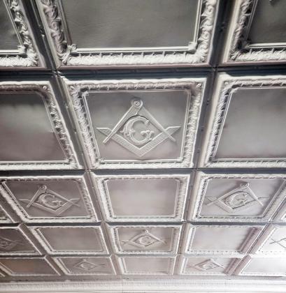 LODGE BRETHREN Metal ceiling tiles in the Lodge room bear the square and compass design.