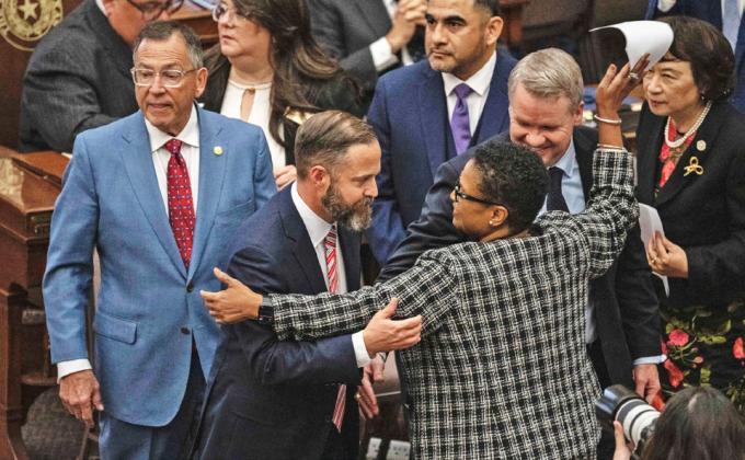 ACROSS THE AISLE State Rep. Toni Rose (D-Dallas) hugs fellow Reps. Dustin Burrows (R-Lubbock) and David Cook (R-Mansfield) after Burrows won the vote for speaker Jan. 14. | ELI HARTMAN/ THE TEXAS TRIBUNE