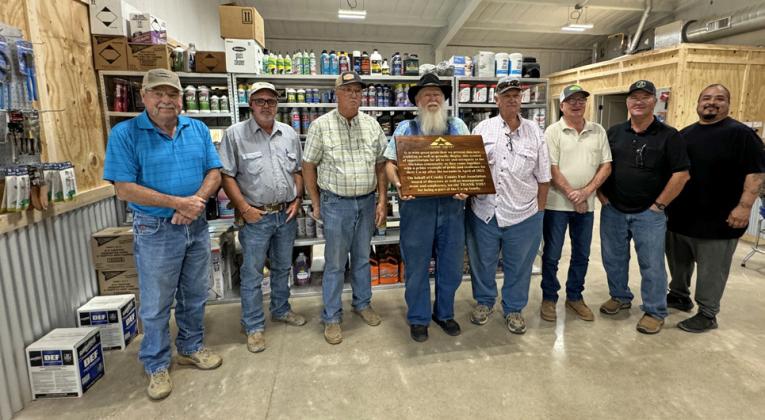 CROSBY COUNTY FUEL ASSOCIATION GRAND REOPENING PRIDE AND RESILIENCE are celebrated in the text of the large, custom-made wooden plaque presented to the Crosby County Fuel Association’s McAdoo location last Friday by general manager Steve Riley. From left, board members Bobby Binder, Dusty Cornelius, Joe Mark Cargile, Mack Gardner (with plaque), Mark Schoepf, Brad Aycock and Russ Edinburgh, and store manager Luis Guzman. | THE TEXAS SPUR