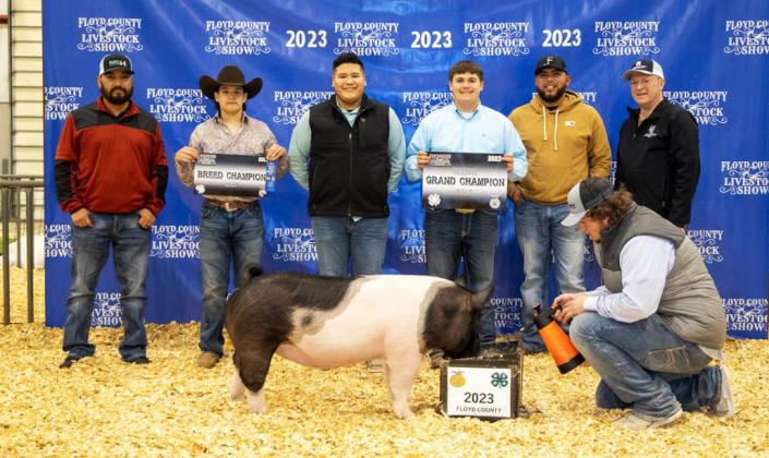 LINEMAN TO LIVESTOCK Green (far right) along with Lighthouse employees Carlos Rendon and Hector Rodriguez helped honor winner Adrian Jimenez, with his grand champion gilt, at the 2023 Floyd County Stock Show. | COURTESY PHOTO