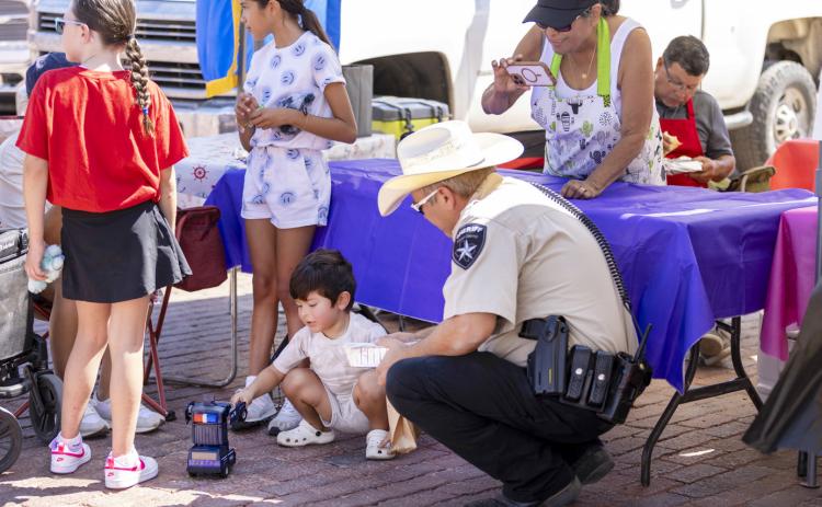 LOCKNEY CITIZENS OF ALL AGES celebrated Lockney Old Fashioned Day last Saturday, Aug. 2025, with food and vendor booths, a dunking tank, and fun and games. Xander Rodriguez (center) ogf Lockney gave some tips to a Floyd County deputy on how to manage a vehicle pursuit! MORE PHOTOS, PAGE 5 | CERVANTES PHOTOGRAPHY